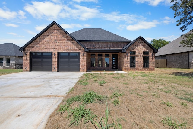 view of front of home featuring a shingled roof, brick siding, driveway, and an attached garage