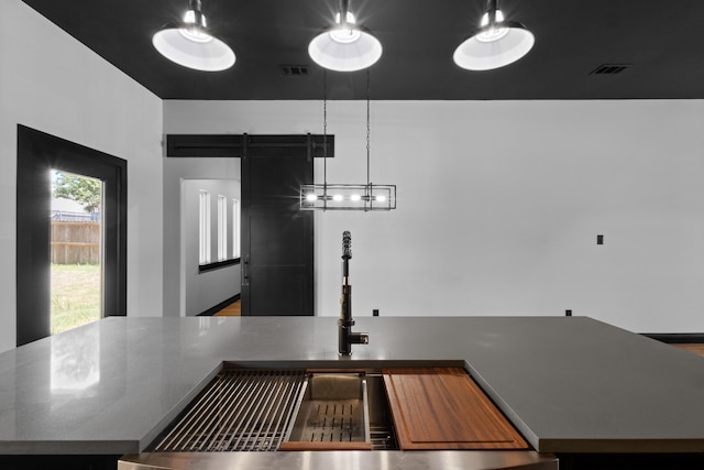 kitchen featuring stone countertops, a barn door, sink, and hardwood / wood-style floors