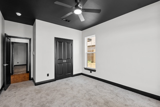 unfurnished bedroom with ceiling fan and carpet