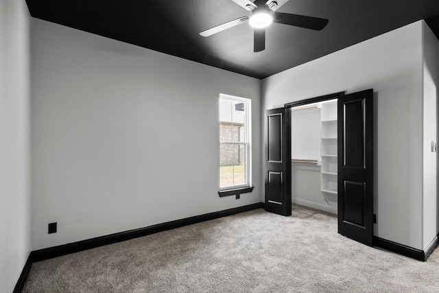 unfurnished bedroom with light carpet, a closet, and ceiling fan