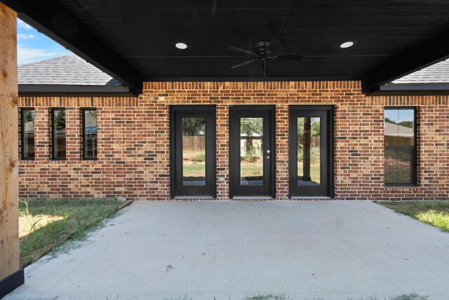 entrance to property with ceiling fan and a patio area