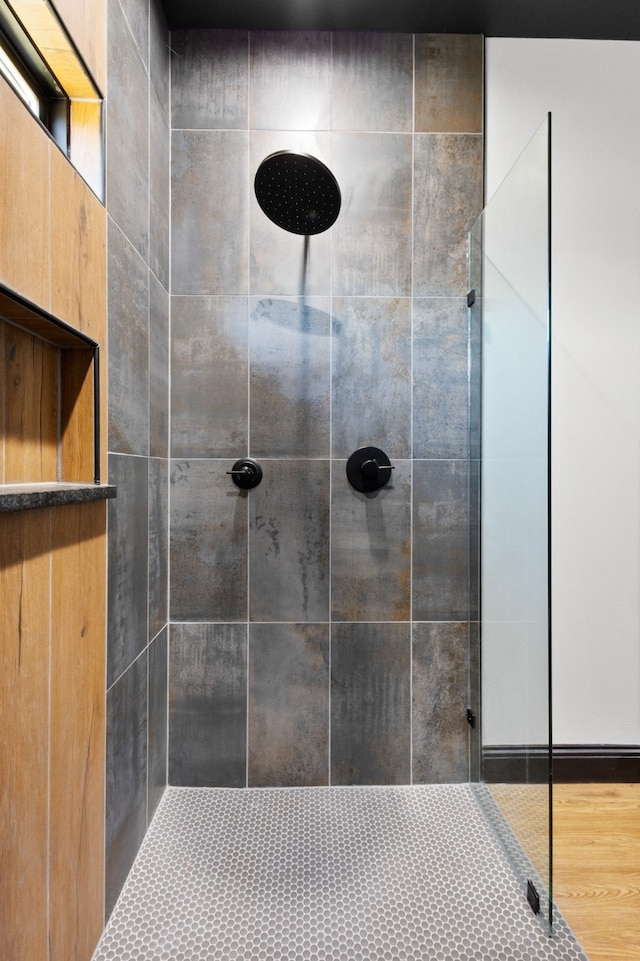 bathroom featuring a tile shower and hardwood / wood-style floors