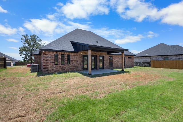 back of property featuring cooling unit, a patio area, and a yard