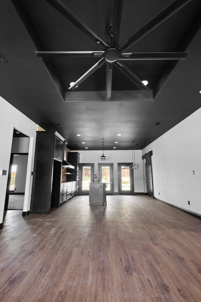 unfurnished living room with ceiling fan and dark wood-type flooring