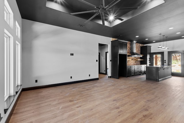 interior space with a towering ceiling and light hardwood / wood-style floors