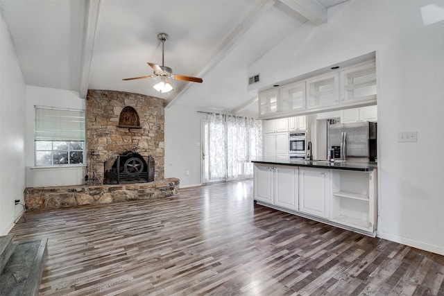 unfurnished living room featuring sink, lofted ceiling with beams, and a wealth of natural light