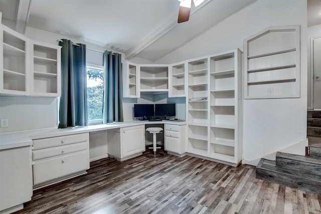 unfurnished office with dark wood-type flooring, ceiling fan, built in desk, and lofted ceiling with beams