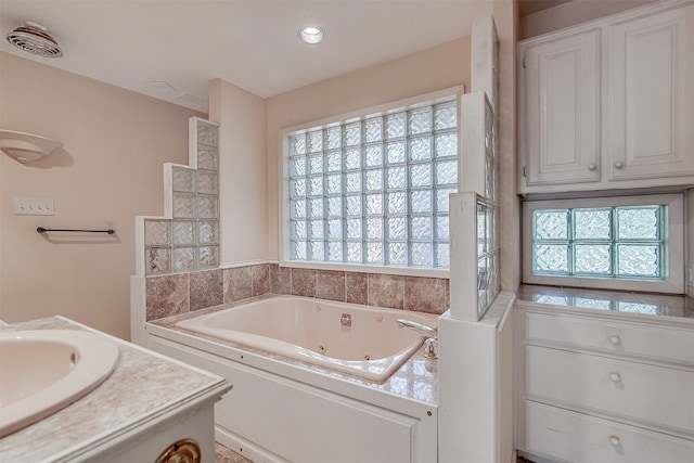 bathroom featuring a tub, vanity, and plenty of natural light