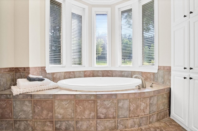 bathroom featuring tile patterned flooring and a relaxing tiled tub