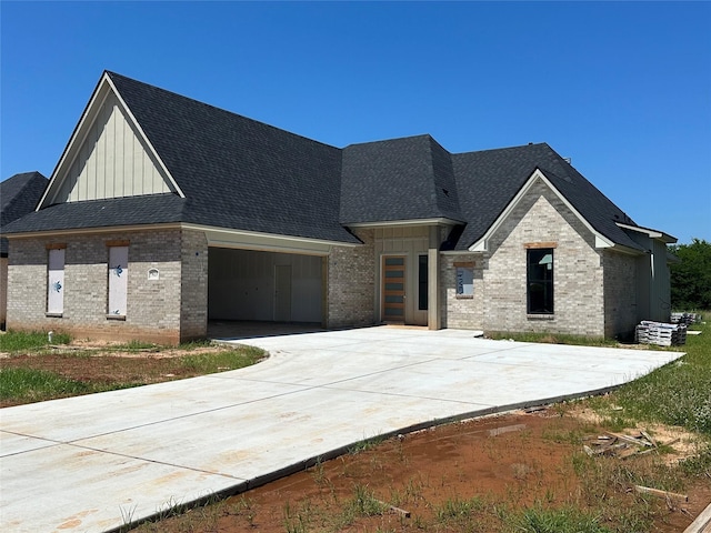 923 Chisolm Trl, Bossier City, LA 71111 - view of front of home featuring board and batten siding, brick siding, a shingled roof, and a garage