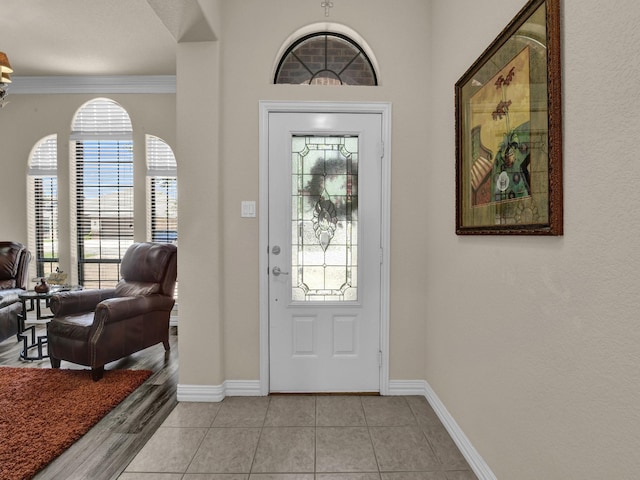 entryway featuring ornamental molding and light tile patterned flooring