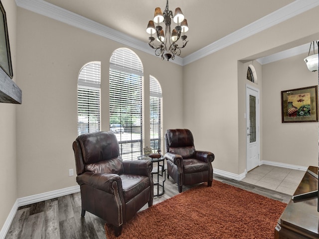 living area with hardwood / wood-style flooring, ornamental molding, and a chandelier