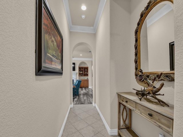 hall with light tile patterned flooring and ornamental molding