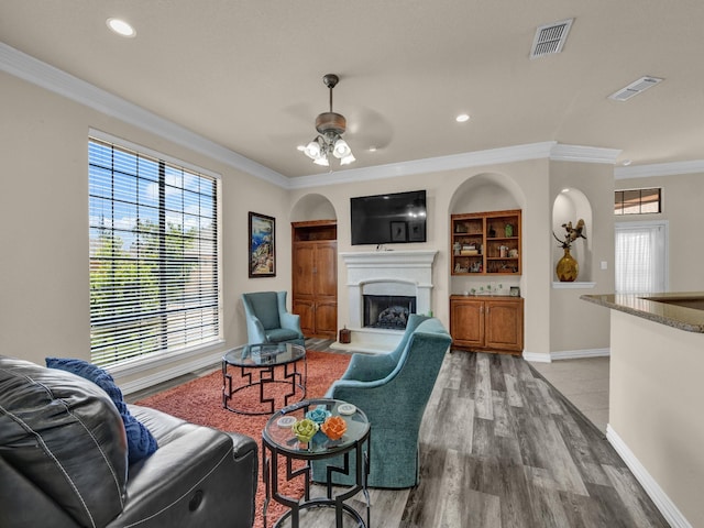 living room with crown molding, hardwood / wood-style floors, and ceiling fan