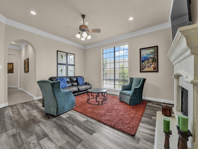 living room with hardwood / wood-style flooring, ornamental molding, and ceiling fan