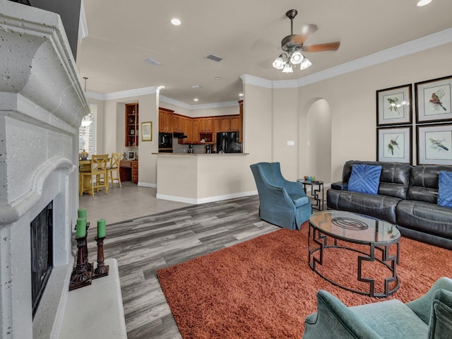 living room with crown molding, ceiling fan, and light wood-type flooring