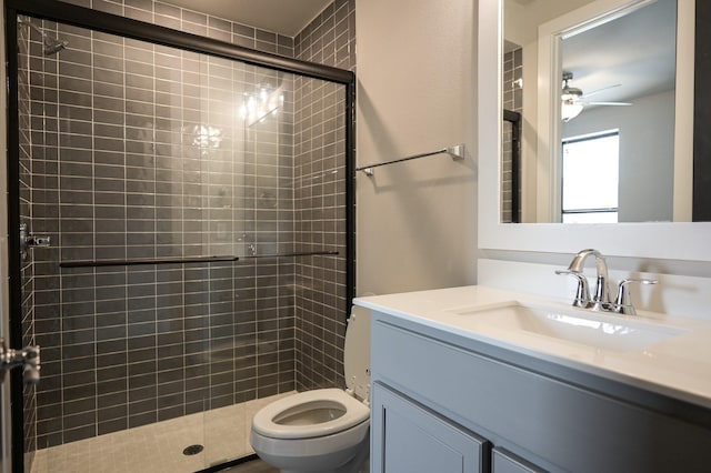 bathroom featuring vanity, a shower with shower door, and toilet