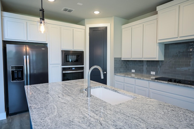 kitchen with stainless steel appliances, sink, white cabinets, and light stone counters