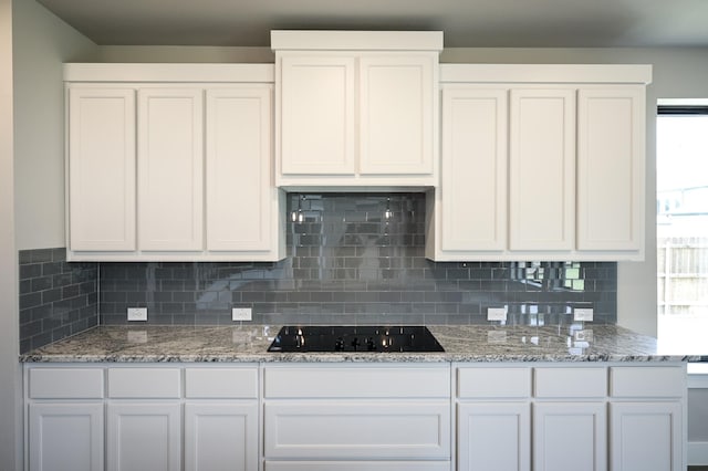 kitchen featuring tasteful backsplash, white cabinetry, and black electric cooktop