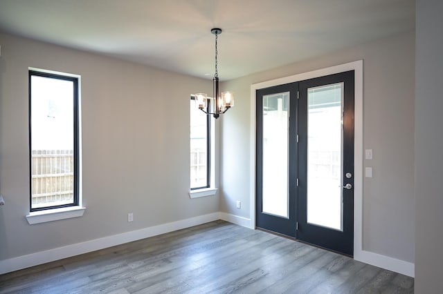 interior space with hardwood / wood-style flooring, a chandelier, and french doors