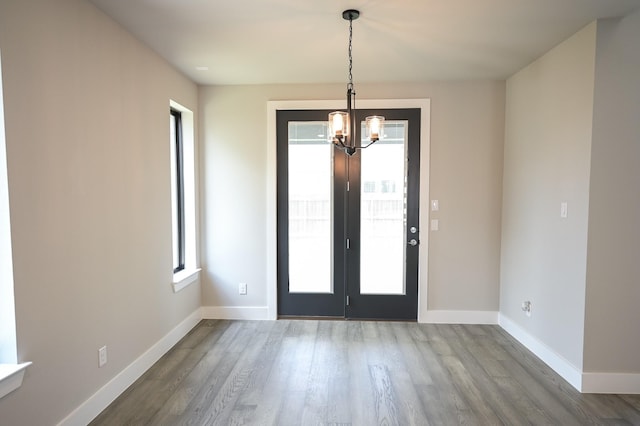 foyer entrance featuring an inviting chandelier, hardwood / wood-style flooring, and plenty of natural light