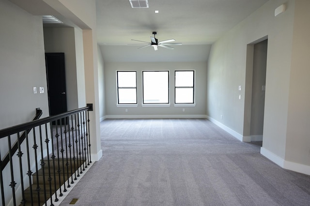 carpeted empty room featuring vaulted ceiling and ceiling fan