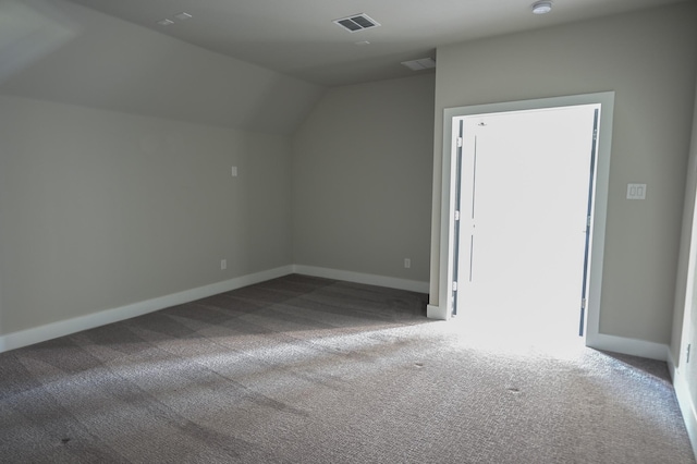 additional living space featuring vaulted ceiling and carpet