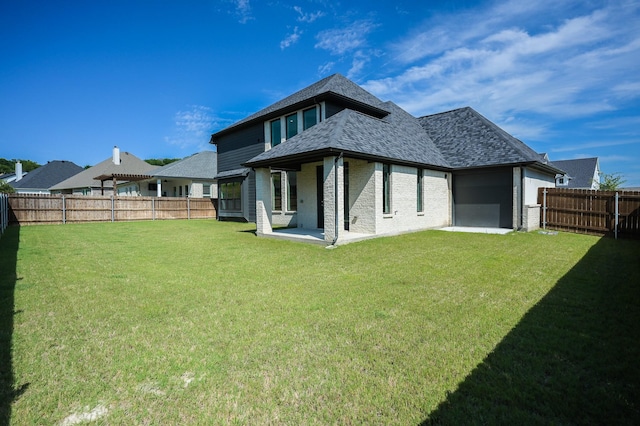 rear view of property featuring a yard and a patio area