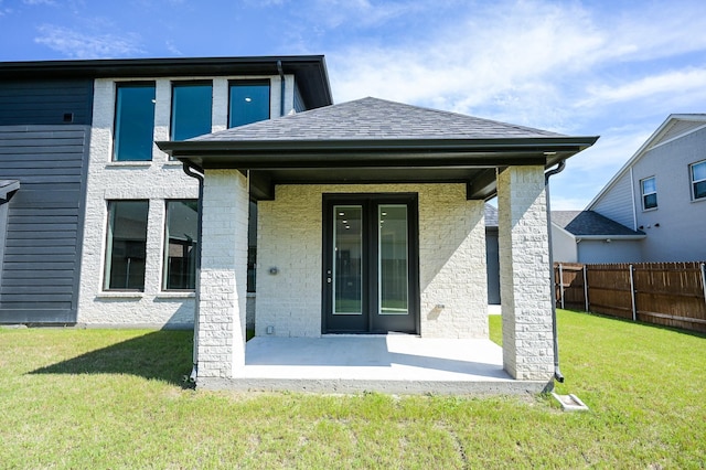 rear view of house with a patio and a lawn