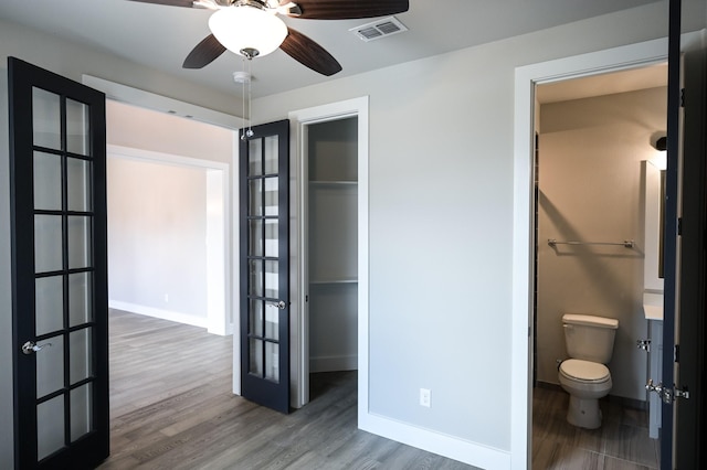 unfurnished bedroom with hardwood / wood-style flooring, ensuite bath, a closet, and french doors