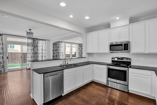 kitchen with appliances with stainless steel finishes, plenty of natural light, and kitchen peninsula