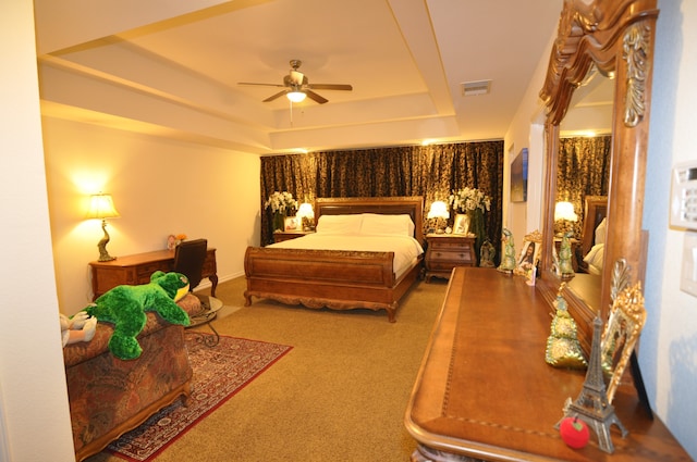 bedroom with a tray ceiling, carpet floors, and ceiling fan