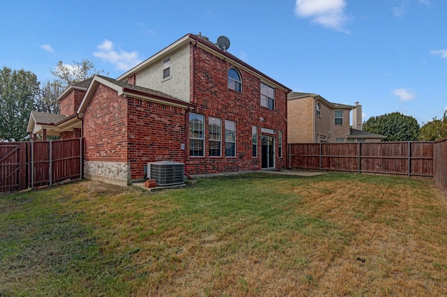 back of house with central AC and a yard