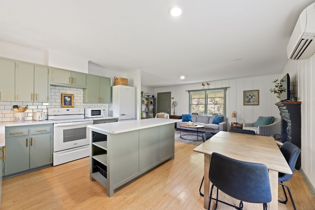 kitchen featuring light hardwood / wood-style flooring, white appliances, backsplash, a center island, and a wall mounted AC