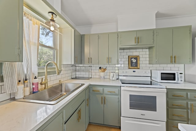 kitchen featuring tasteful backsplash, white appliances, sink, green cabinets, and ornamental molding