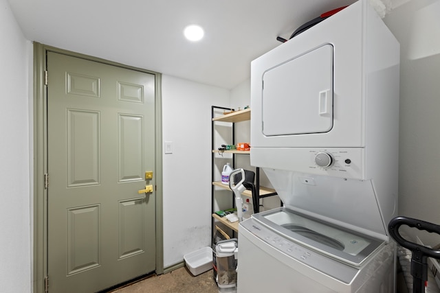 clothes washing area with stacked washing maching and dryer