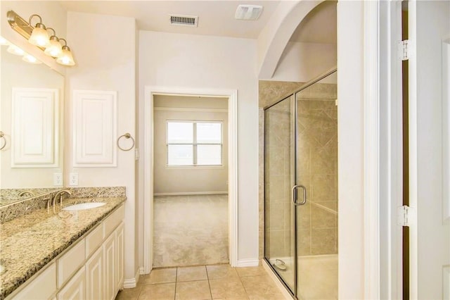 bathroom with tile patterned floors, vanity, and walk in shower