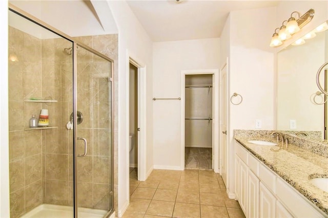 bathroom featuring toilet, tile patterned flooring, vanity, and walk in shower