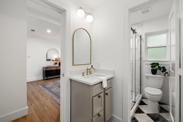 bathroom with wood-type flooring, vanity, toilet, and walk in shower