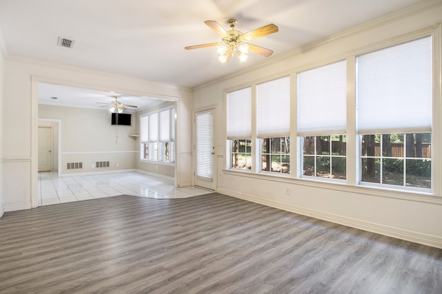 unfurnished living room featuring a fireplace, wood-type flooring, built in features, and ornamental molding