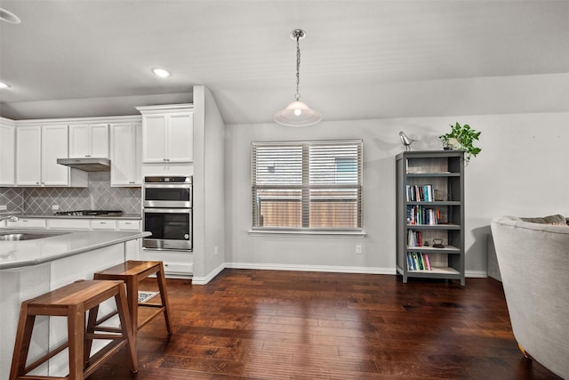 kitchen featuring decorative backsplash, appliances with stainless steel finishes, decorative light fixtures, and white cabinetry