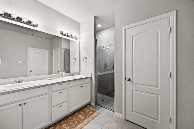 bathroom with tile patterned flooring, vanity, and walk in shower