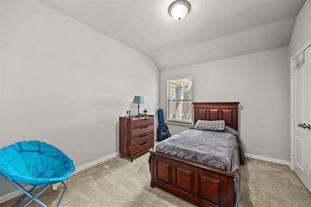 bedroom with light colored carpet and vaulted ceiling