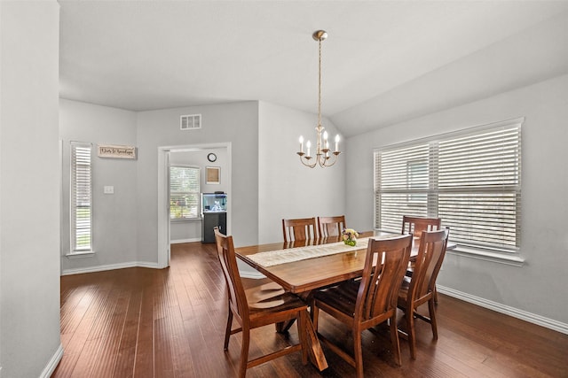 dining room with lofted ceiling, dark wood-type flooring, and a chandelier