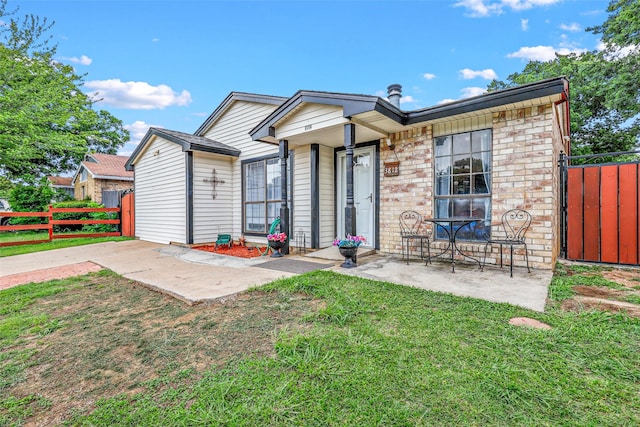 single story home with a patio area and a front yard