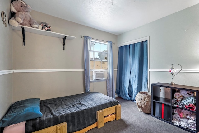 carpeted bedroom with a textured ceiling and cooling unit