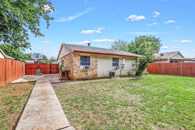 back of property with a lawn, cooling unit, and a patio area