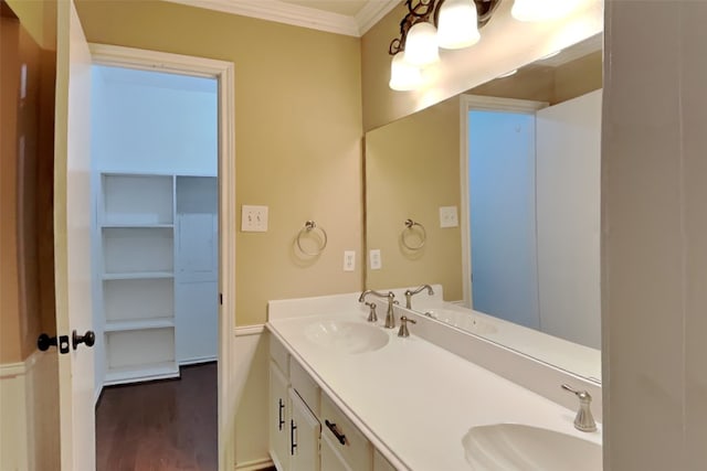 bathroom with double vanity, hardwood / wood-style flooring, and crown molding