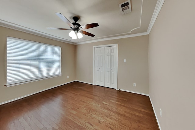 unfurnished bedroom featuring hardwood / wood-style flooring, ornamental molding, a closet, and ceiling fan