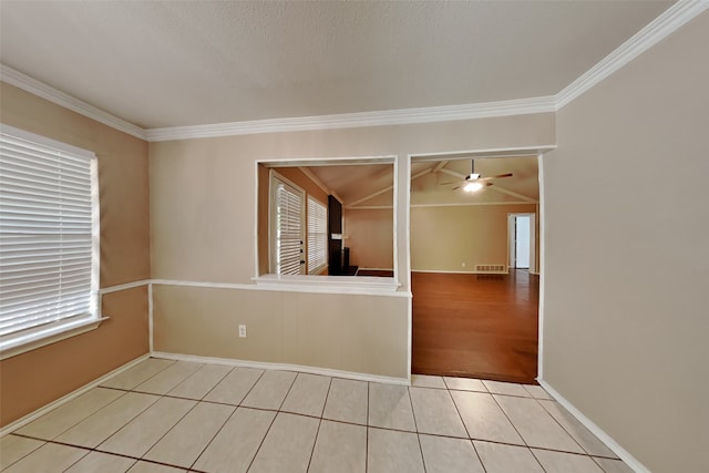 tiled empty room featuring crown molding and ceiling fan